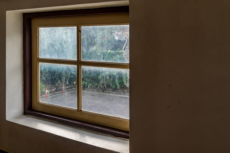 Glass window with wooden frame on concrete wall