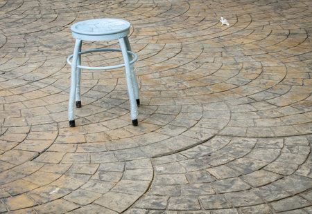 Concrete floor with stone texture stamp with metal mini stoolの写真素材