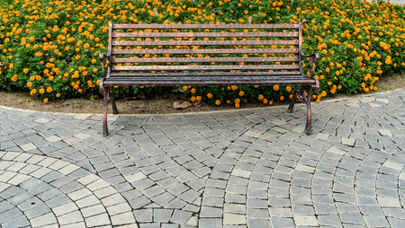 Iron park bench on concrete floor in the gardenの写真素材