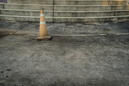 Old Plastic orange cone on the concrete roadの写真素材