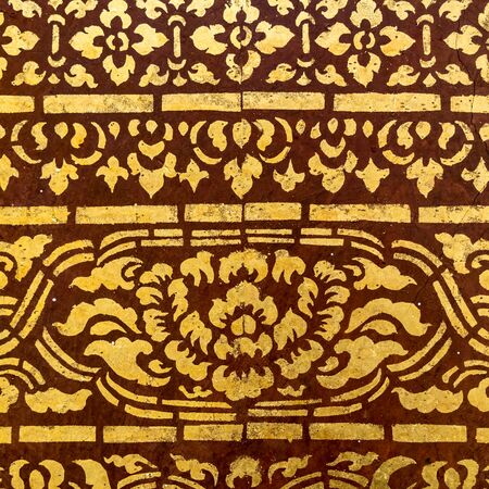 Thai ancient gold pattern on concrete wall in templeの写真素材