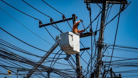 Man working with electricity power line poleの写真素材