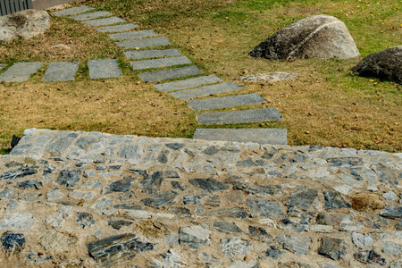 Concrete block pathway with gray stone stair and green lawn