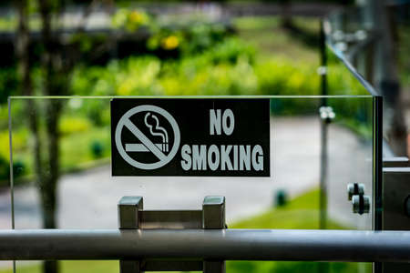 Black No smoking sign on modern glass and stainless railingの写真素材