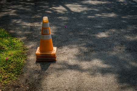 Plastic orange cone on the asphalt roadの写真素材
