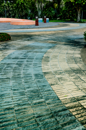 Concrete pathway with green plants in the parkの写真素材