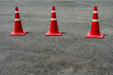 Three orange plastic cones on the asphalt roadの写真素材