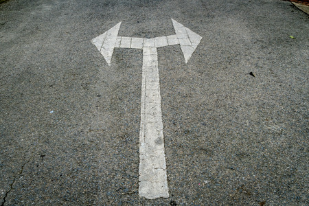 Asphalt road with white two head arrow signの写真素材