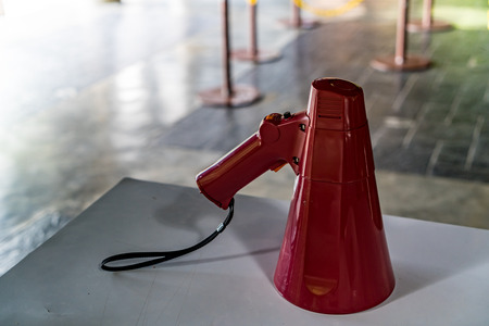Red plastic bullhorn megaphone on white tableの写真素材