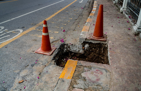 Plastic orange cone at the pothole on asphalt road