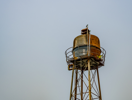 Rusty water tank tower   on blue sky backgroundの写真素材