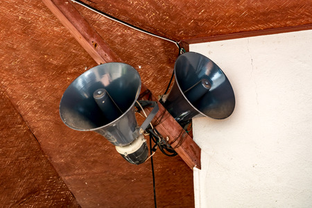 Gray horn speaker on wooden structure of buildingの写真素材