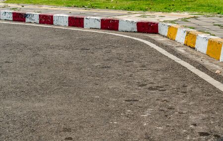 Asphalt road with yellow red and white traffic sign at sidewalk curbの写真素材