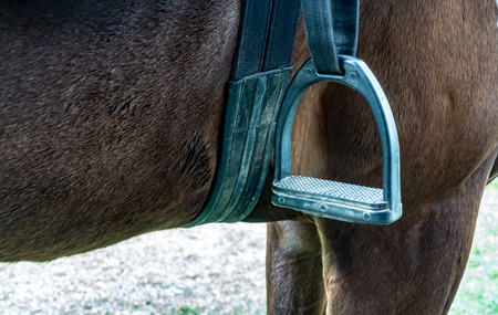 Closeup image of metal stirrup on horse saddleの写真素材