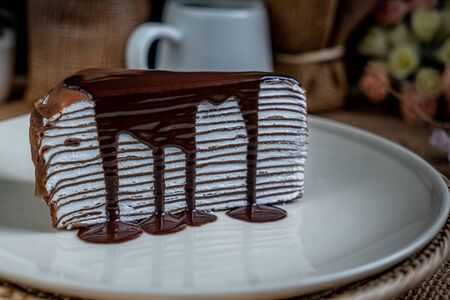 Piece of Chocolate crepe cake on white ceramic plateの写真素材