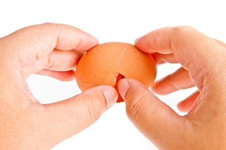 cracked egg in hands on isolatedの写真素材