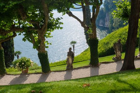 Old statue of man with vine in the park, villa Balbianello, Como lake, Italy.の写真素材