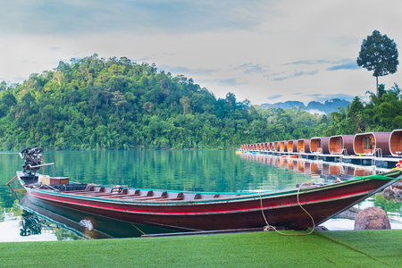 Floating houses at Ratchaprapa dam with wooden boat, Khao sok national park, Thailand.の写真素材