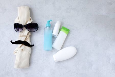 eco-friendly linen light bag with dark glasses and black mustache and a few plastic tube, sunscreen cream or gel. Sun protection, refreshing rejuvenating natural cream. Concept space for design, ecologyの写真素材