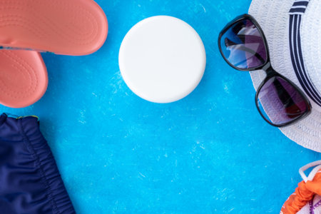 Summer vacation concept, accessories for summer travel flay lay on light blue background with a hat,...