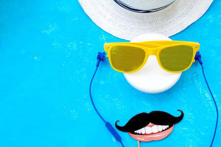 Stylish flat lay created from summer props hat, headphones, glasses and mustache. Summer concept,...