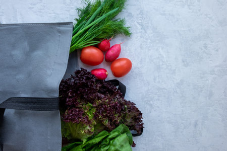 Colorful organic vegetables in green eco shopping bag - captured from above top view, flat lay ....