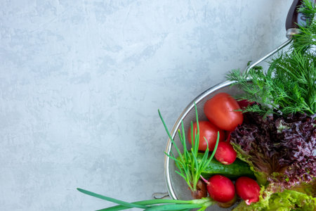 Box with fresh vegetables carrots, tomato, beet, radish, cucumber, pepper on a gray background