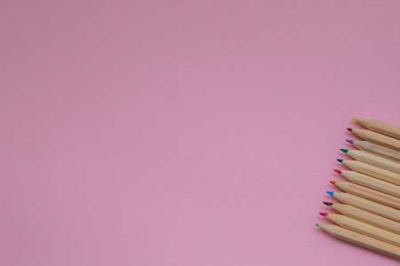 a set of colored pencils on a pink background. Concept Flatley on the topic of back to school