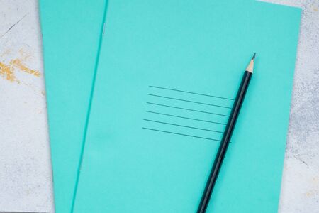 white desktop, green notebook lies on the table, pensil, with copy space, for advertisementの写真素材