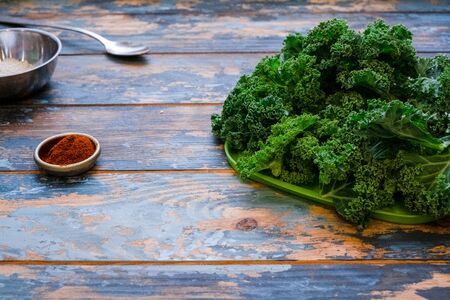 Organic kale with water droplets On the table are the ingredients for the preparation. future chips from fresh Kale cabbage with red pepper and sesame seedsの写真素材