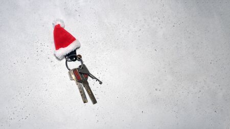 Santa Claus theme: Santa's hand holding the keys to a new appartament on a grey backgroundの写真素材