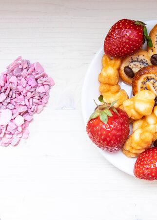fresh and delicious strawberries with cream cookies and poppy seeds on a rustic table with a pink heart on Valentines Day.の写真素材