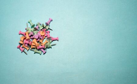 Banner plastic head push pins thumbtacks isolated on blue. Multicolor plastic pins on blue background. flags needles stationery for fixing something. stationery Flatleyの写真素材