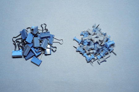 Banner plastic head push pins thumbtacks isolated on blue. Multicolor plastic pins on blue...