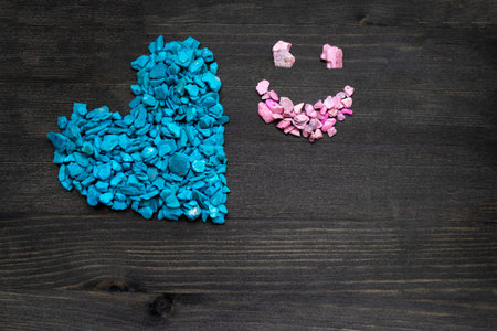 blue heart and pink smiley face on a brown wooden background. Concept happy Valentine's Day, love