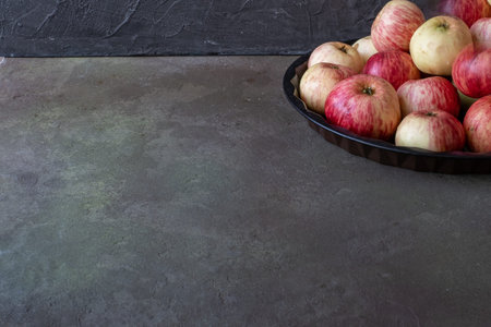 rustic apples on a platter on a dark background. concept-autumn harvest cooking Apple dishes, pies