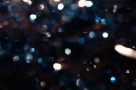 Dark abstract blue bokeh sparkle on black background. Lights of the color background. Defocus different colors lights. Abstract bright blured colored bokeh.の写真素材