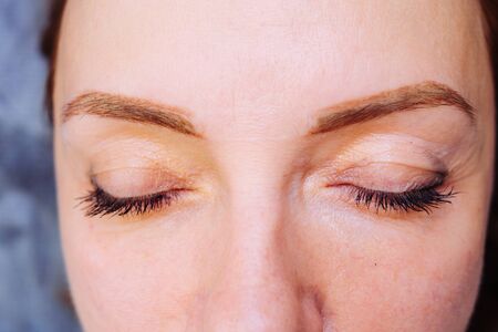 beauty portrait close-up with focus on the eyebrows, in the technique of tattooing spraying. Permanent makeup tattooing of eyebrows.の写真素材