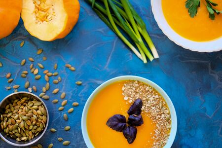 . Top View, sunflower seeds and green onion, purple basil in a serving bowl on a blue background.pumpkin soup with purple Basil on a blue backgroundの写真素材