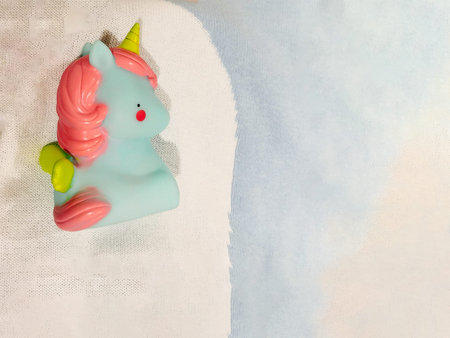 small rubber unicorn in pastel colors with copy space for your text