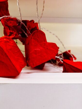 lamps on a wire in the form of hearts.. repairing garland in the form of red hearts. Valentine's day decoration conceptの写真素材