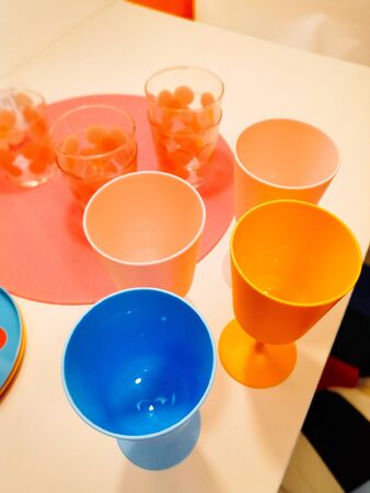 multicolored plastic tableware. Tableware for a picnic made of colored plastic. A stack of plates, mugs, spoons and forks are included in the set of crockery for picnics, tourism and any travel. Plastic ware.の写真素材