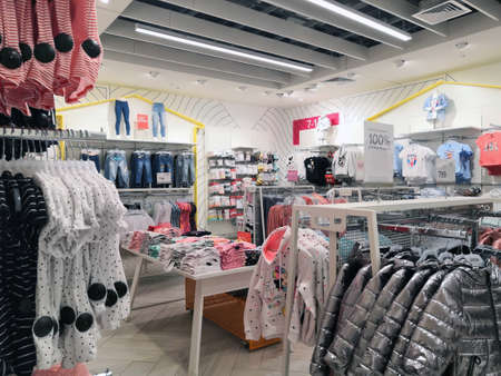 15.03.2020 Moscow, Russia. warm jackets of light silver blue hang on a hanger in a store, winter clothes sale. jackets hanging in the store on a hangerのeditorial素材