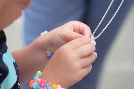 the pendant in the hands of children. Children's hands holding a beautiful chain with a pendant so closeの写真素材