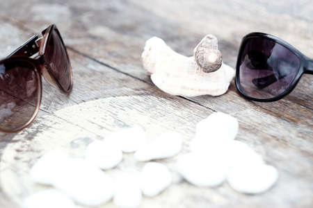 beautiful background black sunglasses and seashells, vacation backgroundの写真素材