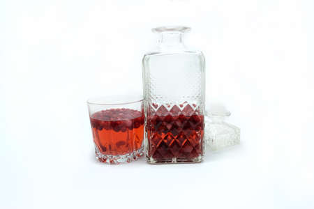 Homemade tincture of red cherry. Berry alcoholic drinks concept. Homemade red wine made from ripe cherries in a glass bottleの写真素材