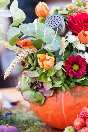 autumn flower composition in pumpkin on the tableの写真素材