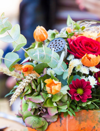 autumn flower composition in pumpkin on the tableの写真素材