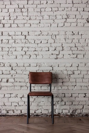Empty modern chair near white brick wall in minimalistic and loft styleの写真素材
