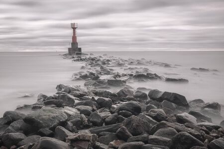 mysterious water, rocky shore and lighthouseの写真素材